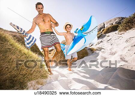 Boy and father walking in sand dune carrying shark inflatable, Cape Town, South Africa View Large Photo Image Stock Photography - Boy and father walking in sand dune carrying shark inflatable, Cape Town, South Africa. Fotosearch