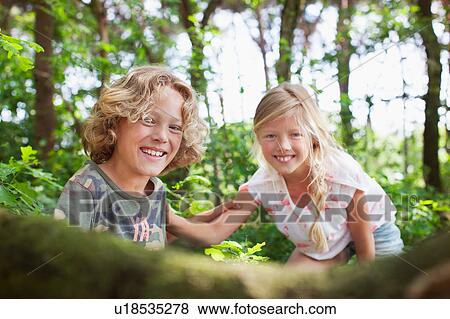 Stock Photo - Boy and girl in forest looking at camera smiling. Fotosearch