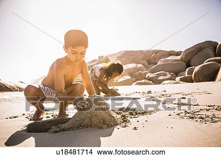 Boy and sister making sandcastle on beach, Cape Town, South Africa View Large Photo Image Picture - Boy and sister making sandcastle on beach, Cape Town, South Africa. Fotosearch