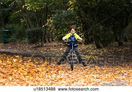 Stock Photo - Boy in park riding bicycle. Fotosearch