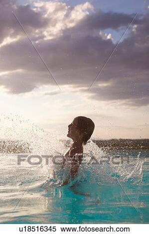 Boy jumping and splashing in swimming pool, Buonconvento, Tuscany, Italy View Large Photo Image Stock Photography - Boy jumping and splashing in swimming pool, Buonconvento, Tuscany, Italy. Fotosearch
