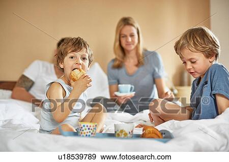 Boys having breakfast in parents bed View Large Photo Image Stock Photo - Boys having breakfast in parents bed. Fotosearch