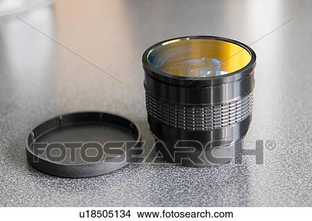 Picture - Camera lens and lid on table. Fotosearch