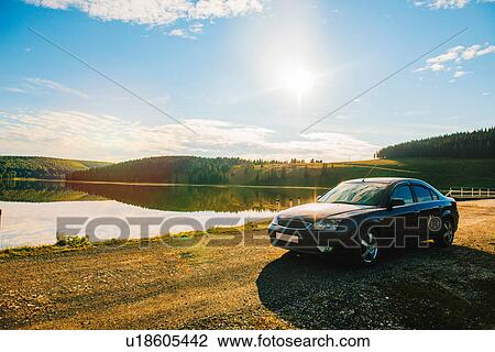 Car parked by lake on rolling landscape View Large Photo Image Stock Image - Car parked by lake on rolling landscape. Fotosearch