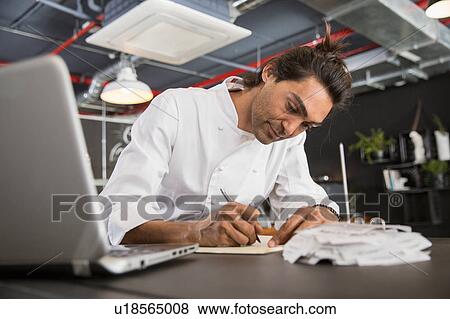 Chef in restaurant writing in notepad View Large Photo Image Stock Photo - Chef in restaurant writing in notepad. Fotosearch