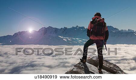 Climber looking out at sunset from peak emerging from fog, Bettmeralp, Valais, Switzerland View Large Photo Image Stock Photo - Climber looking out at sunset from peak emerging from fog, Bettmeralp, Valais, Switzerland. Fotosearch