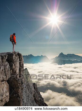 Picture - Climber looking out from peak emerging from fog in the Alps, Bettmeralp, Valais, Switzerland. Fotosearch