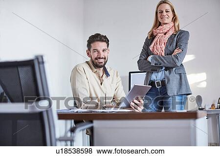 Colleagues in office using digital tablet looking at camera smiling View Large Photo Image Stock Photo - Colleagues in office using digital tablet looking at camera smiling. Fotosearch
