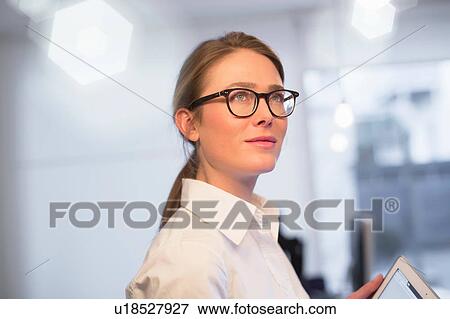 Stock Photo - Confident businesswoman using digital tablet in office. Fotosearch