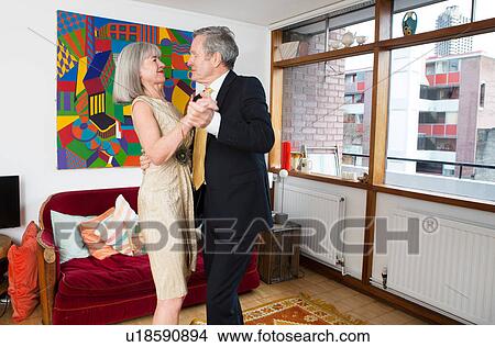 Picture - Couple dressed up and dancing at home. Fotosearch