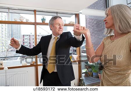 Stock Image - Couple dressed up and dancing at home. Fotosearch