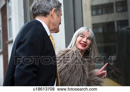 Stock Photo - Couple dressed up and interested in shop window. Fotosearch