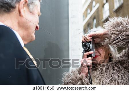 Stock Photograph - Couple dressed up and taking photograph. Fotosearch