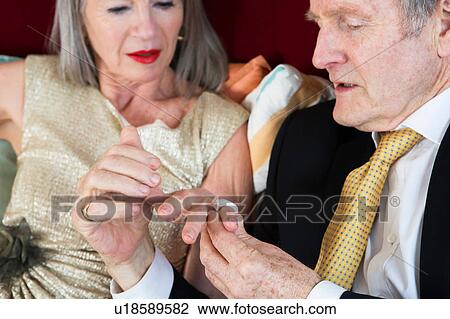 Stock Image - Couple dressed up, relaxing at home. Fotosearch