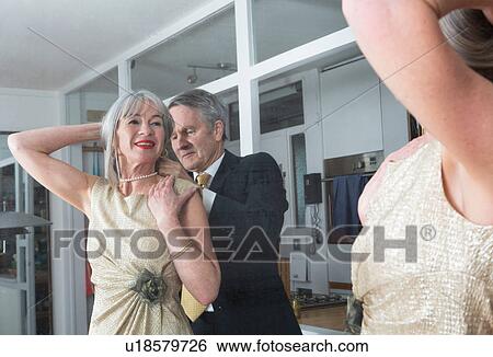Couple dressing up getting ready in front of mirror View Large Photo Image Stock Photograph - Couple dressing up getting ready in front of mirror. Fotosearch
