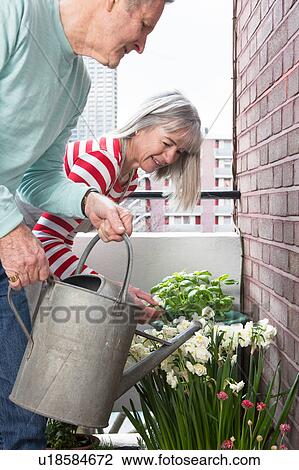 Stock Image - Couple gardening on balcony. Fotosearch