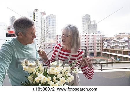 Stock Image - Couple gardening on balcony. Fotosearch