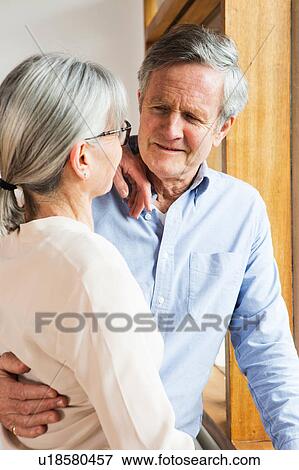 Couple hugging beside window View Large Photo Image Stock Photo - Couple hugging beside window. Fotosearch