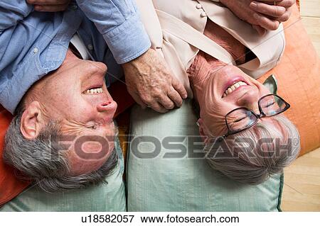 Couple laughing on floor View Large Photo Image Stock Photo - Couple laughing on floor. Fotosearch
