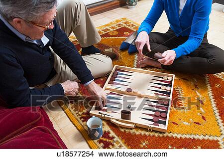 Picture - Couple playing backgammon on floor. Fotosearch