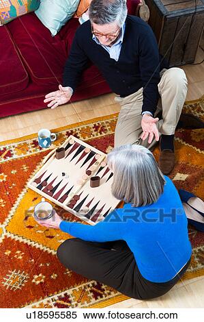 Couple playing backgammon on floor View Large Photo Image Stock Photography - Couple playing backgammon on floor. Fotosearch