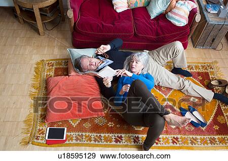 Stock Photo - Couple reading book on floor. Fotosearch