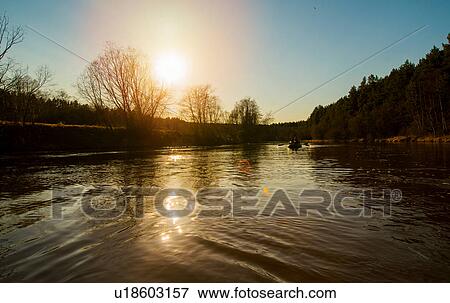 Stock Photo - Couple rowing down lake in dinghy. Fotosearch