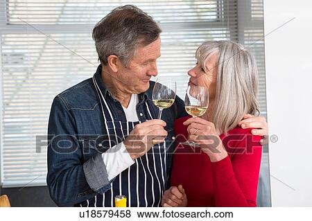 Couple toasting in kitchen View Large Photo Image Stock Photo - Couple toasting in kitchen. Fotosearch