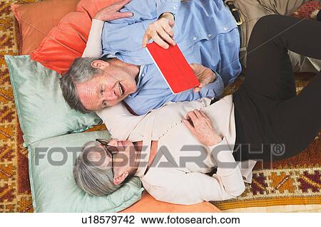 Stock Image - Couple using digital tablet on floor. Fotosearch