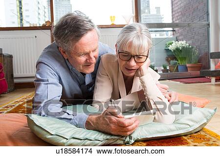 Picture - Couple using smartphone on floor. Fotosearch