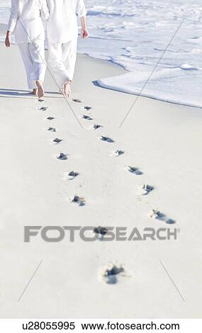 Stock Photography - Couple walking along a beach. Fotosearch