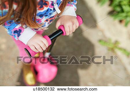 Cropped high angle view of girl on scooter View Large Photo Image Stock Image - Cropped high angle view of girl on scooter. Fotosearch