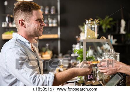 Customer handing smiling restaurant worker credit card View Large Photo Image Stock Photo - Customer handing smiling restaurant worker credit card. Fotosearch