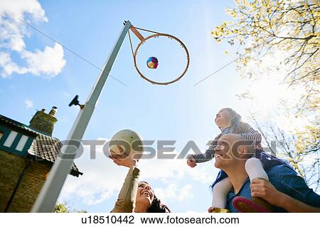 Family throwing basketball through basketball hoop View Large Photo Image Stock Image - Family throwing basketball through basketball hoop. Fotosearch