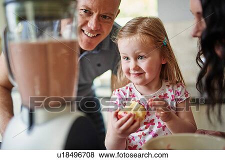 Stock Photo - Family watching smoothie in blender smiling. Fotosearch