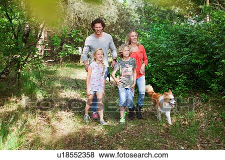 Family with dog walking together in forest View Large Photo Image Stock Photo - Family with dog walking together in forest. Fotosearch