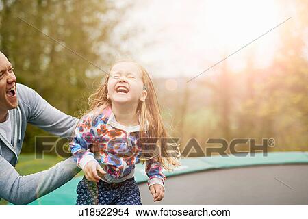 Father and daughter playing on trampoline View Large Photo Image Picture - Father and daughter playing on trampoline. Fotosearch