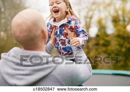 Father and daughter playing on trampoline View Large Photo Image Stock Photo - Father and daughter playing on trampoline. Fotosearch