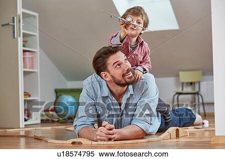 Stock Photography - Father and son playing with toy aeroplane. Fotosearch