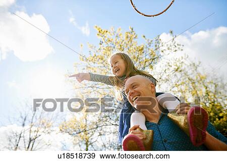 Stock Photo - Father carrying daughter on shoulders. Fotosearch