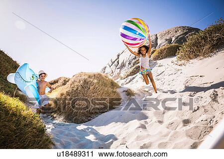 Girl and brother running down sand dune carrying shark inflatable and beachball, Cape Town, South Africa View Large Photo Image Stock Image - Girl and brother running down sand dune carrying shark inflatable and beachball, Cape Town, South Africa. Fotosearch
