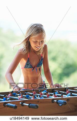 Stock Photo - Girl in garden playing table football, Buonconvento, Tuscany, Italy. Fotosearch