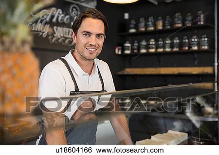 Stock Photograph - Happy restaurateur behind service counter. Fotosearch