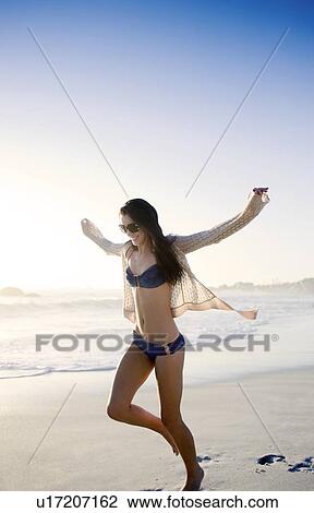 Stock Image - Happy woman on a beach. Fotosearch