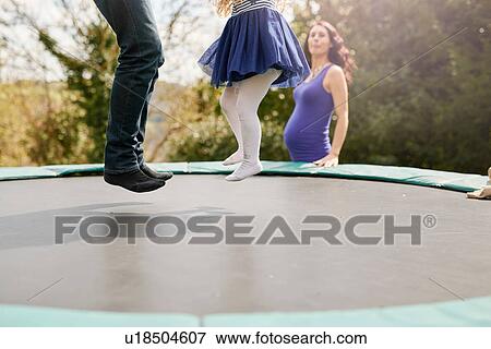 Low section of father and daughter bouncing on trampoline View Large Photo Image Stock Photo - Low section of father and daughter bouncing on trampoline. Fotosearch