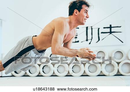 Stock Photo - Man doing jump push up, hand together smiling. Fotosearch
