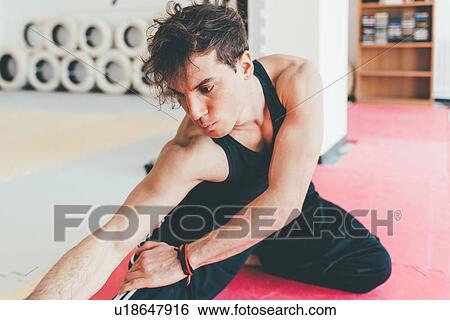 Stock Photograph - Man doing leg stretching exercise. Fotosearch
