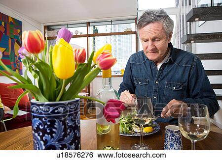 Man enjoying meal at dining table View Large Photo Image Stock Photograph - Man enjoying meal at dining table. Fotosearch
