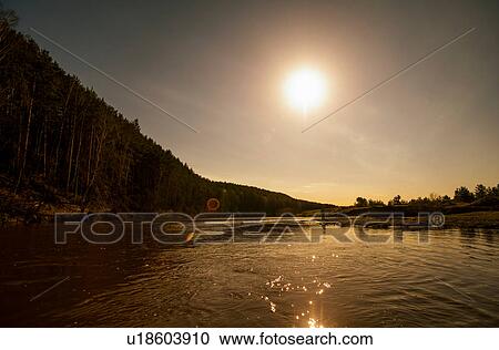 Man fishing in lake by edge of forest View Large Photo Image Stock Image - Man fishing in lake by edge of forest. Fotosearch
