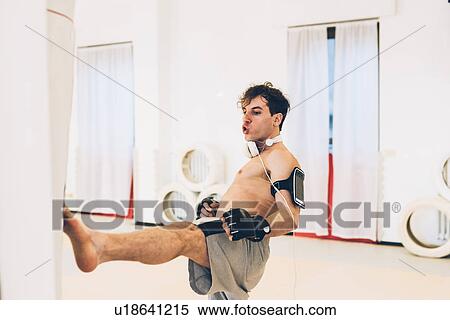 Man in gym wearing heart rate monitor kicking punch bag View Large Photo Image Stock Photography - Man in gym wearing heart rate monitor kicking punch bag. Fotosearch